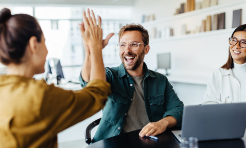 Man die een high five geeft aan medewerker, Coachend leiderschap